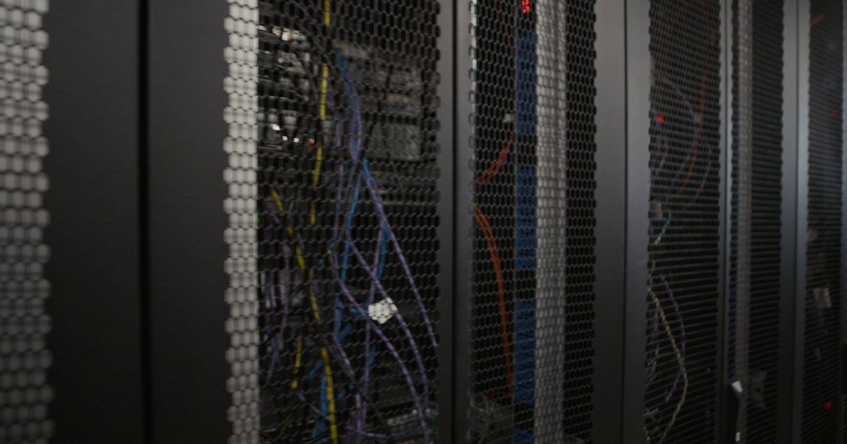 Rows of server racks with network cables in a data center